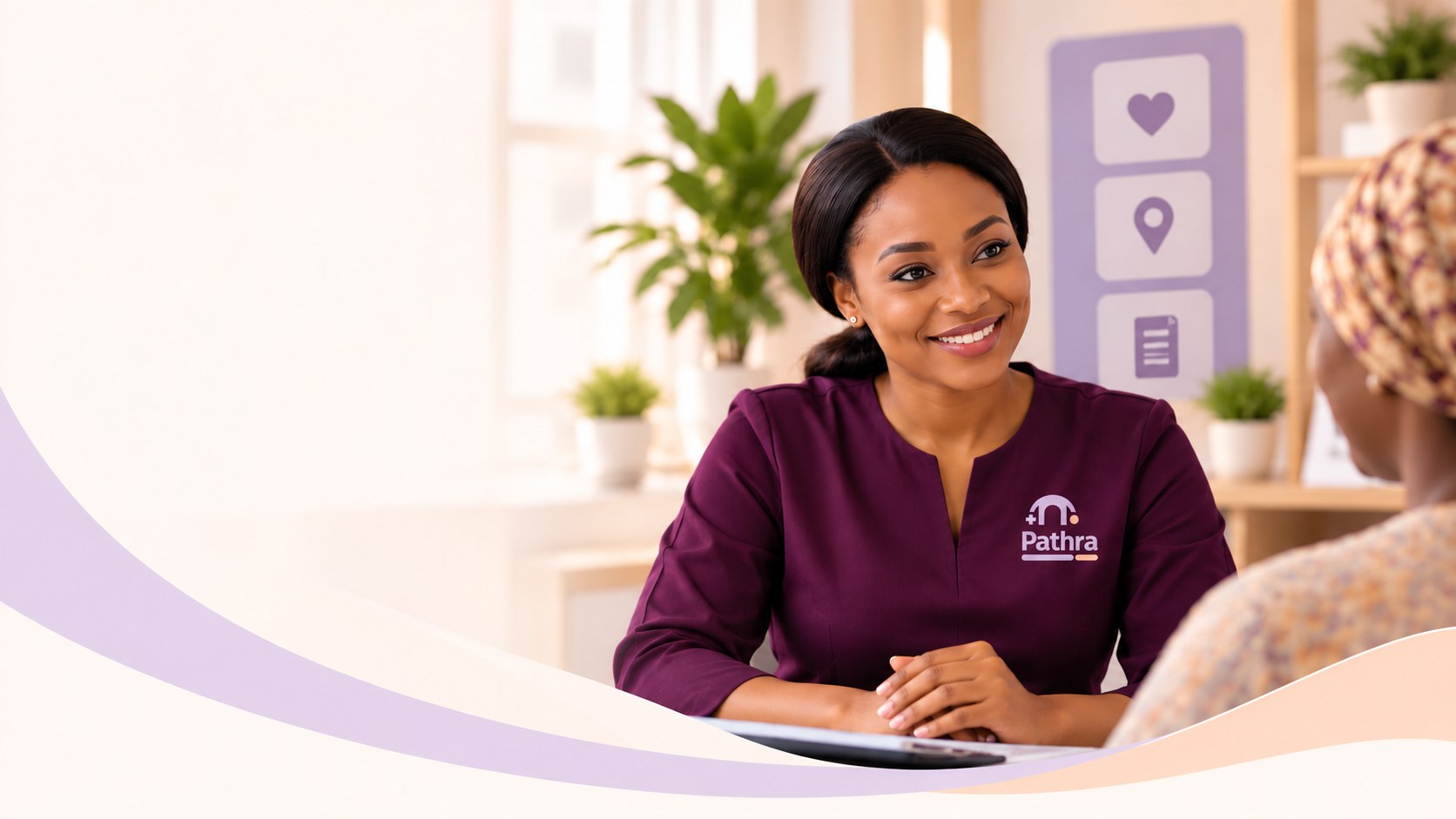 A Pathra care coordinator in a deep plum uniform smiling as she talks with a visitor in a bright, welcoming consultation room
